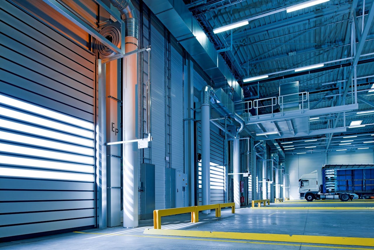 about-02 Spacious and modern warehouse interior with parked truck and steel structures.